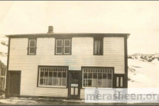 The "new" Co-op store in 1949 with a 6-years old Ernie Walsh.&amp;nbsp;&amp;nbsp;By 1946, Co-op number three had become too small and at a board meeting in October 1946, they decided to build this larger store. John J Ennis and James Connors accepted the job of lead hands and were to be paid the grand sum of thirty-five cents an hour, helpers were to be paid a princely thirty cents an hour. At a board meeting in March 1947, a motion was passed that Co-op number three be closed April 4 and April 5 to facilitate the movement of inventory to the new building. The Co-op store opened for it's first day of business on April 7,1947.&amp;nbsp;To the left are the remains of the old parish hall down stairs and school up-stairs, shown by the old vertical sticks and the sloped roof.